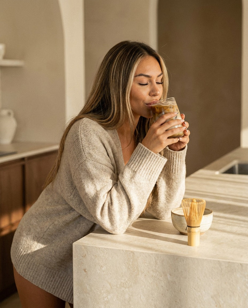 A woman relaxing with a hōjicha latte in the afternoon